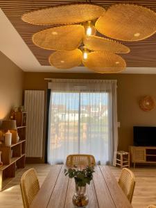 a dining room with a wooden table and a chandelier at La Cremaillere Hôtel-Restaurant in Courseulles-sur-Mer