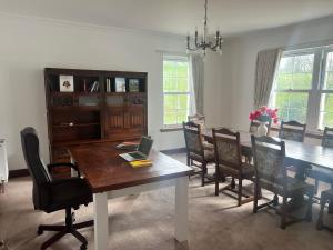 a dining room with a table with a laptop on it at Coylebrae House in Ayr