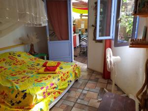 1 dormitorio con 1 cama con edredón amarillo en L'Atelier Gîtes des Koalas, en Terre-de-Bas