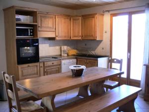 uma cozinha com armários de madeira e uma mesa de madeira em Chalet Les Aiguilles - Pièces 34 em Valloire