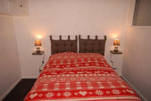 - une chambre avec un lit rouge et deux lampes dans l'établissement Résidence ISARDS - 2 Pièces pour 8 Personnes 094, à Gourette