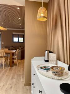 a kitchen with a white counter and a dining room at La Cremaillere Hôtel-Restaurant in Courseulles-sur-Mer