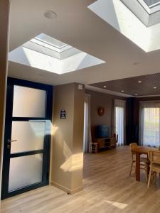 a living room with a ceiling with a skylight at La Cremaillere Hôtel-Restaurant in Courseulles-sur-Mer