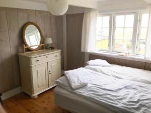 Dormitorio con cama con espejo y tocador en Charming old style shanty en Hvalba