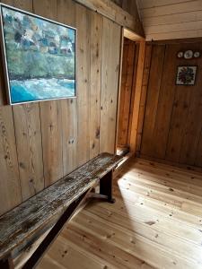 una habitación vacía con un banco en una cabaña en Charming old style shanty en Hvalba