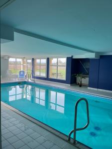 a swimming pool with blue water in a building at Beaune/levernois Appartement1 chambre+1canapé lit in Levernois