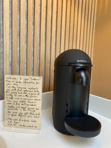 a black coffee maker with a note next to it at La Cremaillere Hôtel-Restaurant in Courseulles-sur-Mer