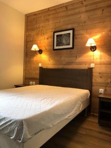 a bedroom with a bed and two lights on the wall at Les Chalets Valoria - 3 Pièces pour 6 Personnes 54 in Valloire