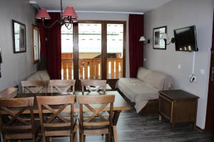 a living room with a table and chairs and a couch at Les Chalets Valoria - 3 Pièces pour 6 Personnes 24 in Valloire