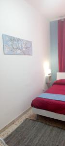 a bedroom with a bed and a painting on the wall at A 2 passi da tutto in Trapani