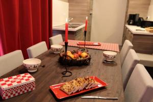 una mesa con un bol de fruta y velas. en Les Chalets D'adrien - 4 Pièces pour 8 Personnes 44, en Valloire