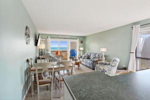 a kitchen and living room with a table and chairs at C223C Daze Aaah View Oceanfront Community Pool in Duck
