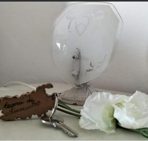 a table with a mirror and a key and a flower at Carru de ammentos in Ozieri