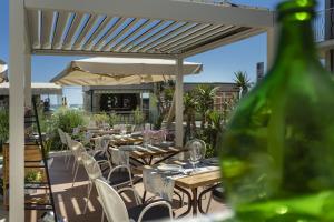 a patio with tables and chairs and an umbrella at Hotel Eliseo in Bellaria-Igea Marina