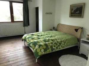 a bedroom with a bed with a green comforter at Charmante villa des années 30 in Abeiche