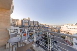 a balcony with a table and chairs and a city at The Pinnacle Fl6 city escape by Homely in Mellieħa