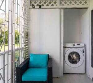 Habitación con lavadora y silla azul en C'DaView Royal Suite, en Montego Bay