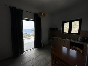 une cuisine avec une fenêtre donnant sur l'océan dans l'établissement 4Seasons Sfakia, à Chóra Sfakíon