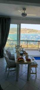 a table in a room with a view of the ocean at Mellieha Bay Seafront With Spectacular Views3bed in Mellieħa