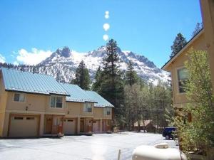 ein Haus mit einem schneebedeckten Berg im Hintergrund in der Unterkunft Hideaway Down Canyon #101 in June Lake