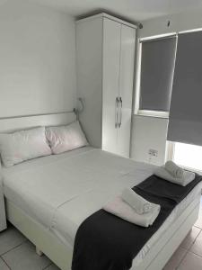 Un dormitorio blanco con una cama grande con toallas. en Mellieha Bay Seafront With Spectacular Views3bed, en Mellieħa