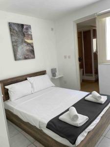 1 dormitorio con 1 cama grande y 2 toallas. en Mellieha Bay Seafront With Spectacular Views3bed, en Mellieħa