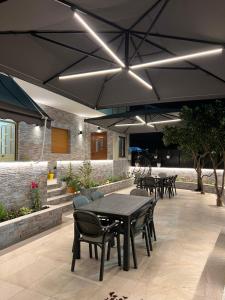 a patio with a black table and chairs and a table and umbrella at VILA Eljus in Durrës