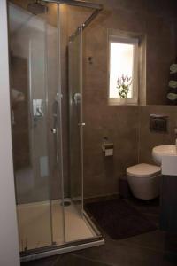 a bathroom with a shower and a toilet and a sink at Southridge Ph With Jacuzzi, Top Views By Homely in Mellieħa +24 photos