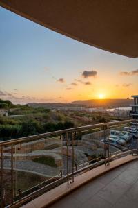 a balcony with a view of the sunset at Mellieha Bay Designer Apartment By Homely in Mellieħa