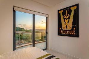 a bedroom with a bed and a large window at Mellieha Bay Designer Apartment By Homely in Mellieħa