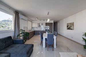 uma sala de estar e cozinha com uma mesa e um sofá em Luxe 3br Melliehabay Retreat And Stunning Terrace em Mellieħa
