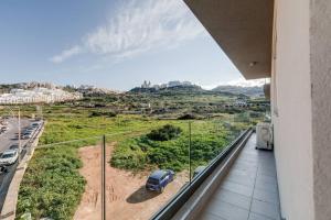 a balcony with a car parked on a street at Luxe 3br Melliehabay Retreat And Stunning Terrace in Mellieħa