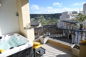 a hot tub on the balcony of a building at Ta'lonza Luxury Near Goldenbay With Hot Tub App3 in Mellieħa
