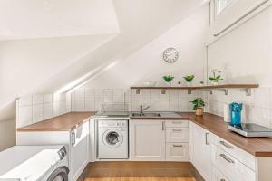 a white kitchen with a washer and dryer at DHG Luxury Apartments Heart of Zurich in Zurich