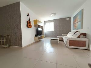 a living room with a bed and a guitar on the wall at Cosy 2bed Apartment In Manikata By Homely in Mellieħa