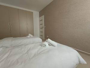 two beds in a room with white sheets and towels at Cosy 2bed Apartment In Manikata By Homely in Mellieħa