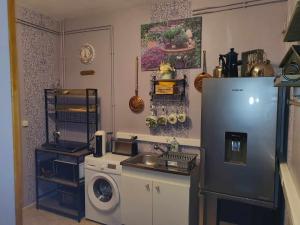 a kitchen with a refrigerator and a washing machine at Chez Yvonne in Oye-Plage