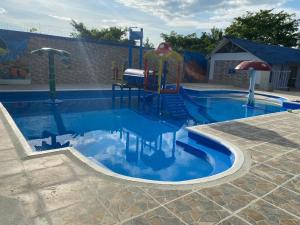 a swimming pool with a playground with a slide at hotel Vila orlanda finca hotel eventos in Montería