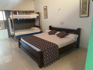 a bedroom with a bed and bunk beds at hotel Vila orlanda finca hotel eventos in Montería