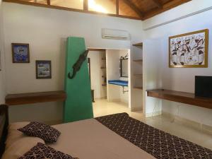 1 dormitorio con 1 cama con un objeto verde en la pared en hotel Vila orlanda finca hotel eventos, en Montería