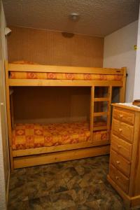 a wooden bunk bed in a room with a dresser at Residence Les Choseaux - 2 Pièces pour 6 Personnes 764 in Valloire
