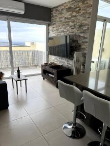 sala de estar con chimenea, mesa y sillas en Pearlcourt 1 Bedroom Ph Mellieha, en Mellieħa
