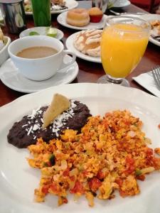 um prato de comida e um copo de sumo de laranja em Hotel Argento em Cuernavaca