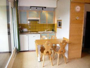 a kitchen with a wooden table and two chairs at Résidence Les Glovettes - 2 Pièces pour 6 Personnes 624 in Villard-de-Lans