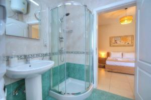 ein Bad mit einer Dusche, einem Waschbecken und einem Bett in der Unterkunft Jonathan Cassar St Julians Lovely 3 Bedrooms in Taʼ Ċikkun