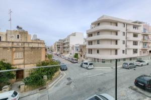 a view of a city street with buildings and cars at Grand 3BED Burseley Terrace fl2 Swieqi by Homely in Is-Swieqi