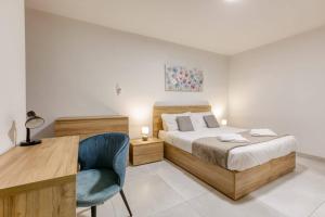 a bedroom with a bed and a desk and a chair at Grand 3BED Burseley Terrace fl2 Swieqi by Homely in Is-Swieqi