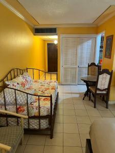 Schlafzimmer mit einem Bett, einem Tisch und einem Tisch in der Unterkunft Sunny Tides at Montego Bay Club Resort in Montego Bay