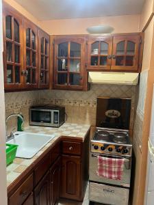 uma cozinha com armários de madeira e um forno com placa de fogão em Sunny Tides at Montego Bay Club Resort em Montego Bay