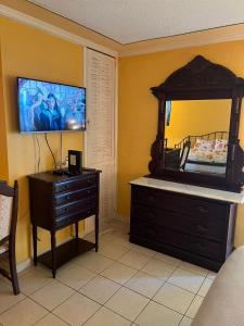 een slaapkamer met een bed, een dressoir en een spiegel bij Sunny Tides at Montego Bay Club Resort in Montego Bay